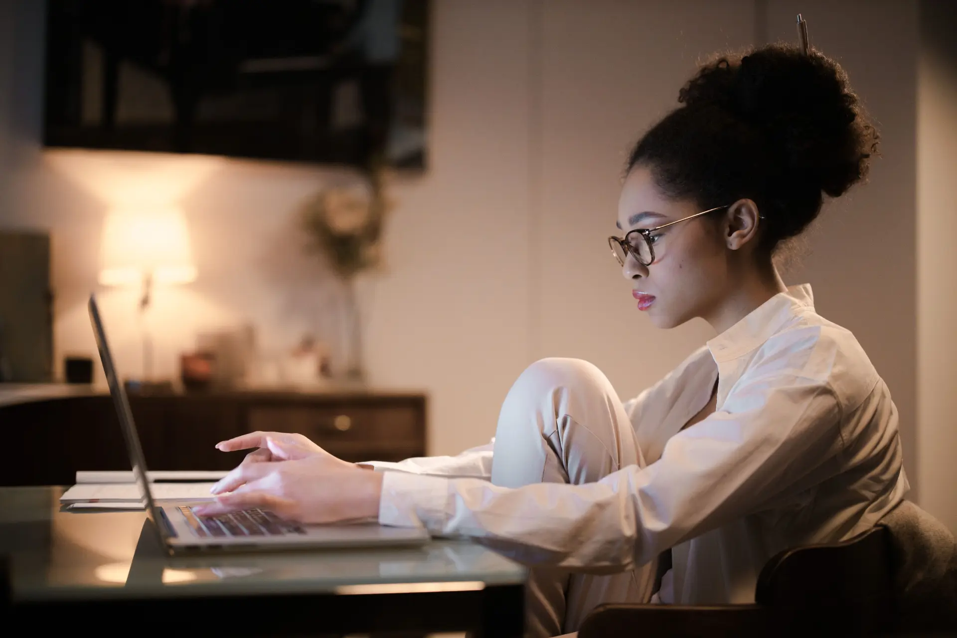A woman entrepreneur working on a laptop in warm evening light